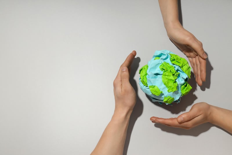 Three hands surrounding a earth-like globe made of packaging paper. Three hands surrounding a earth-like globe made of packaging paper.